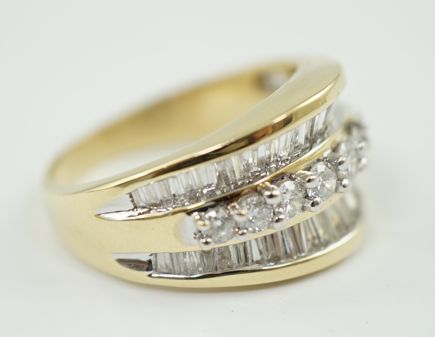 A modern 14k gold and three row baguette and round brilliant cut diamond set dress ring, based on the design of the Crown on the Statue of Liberty